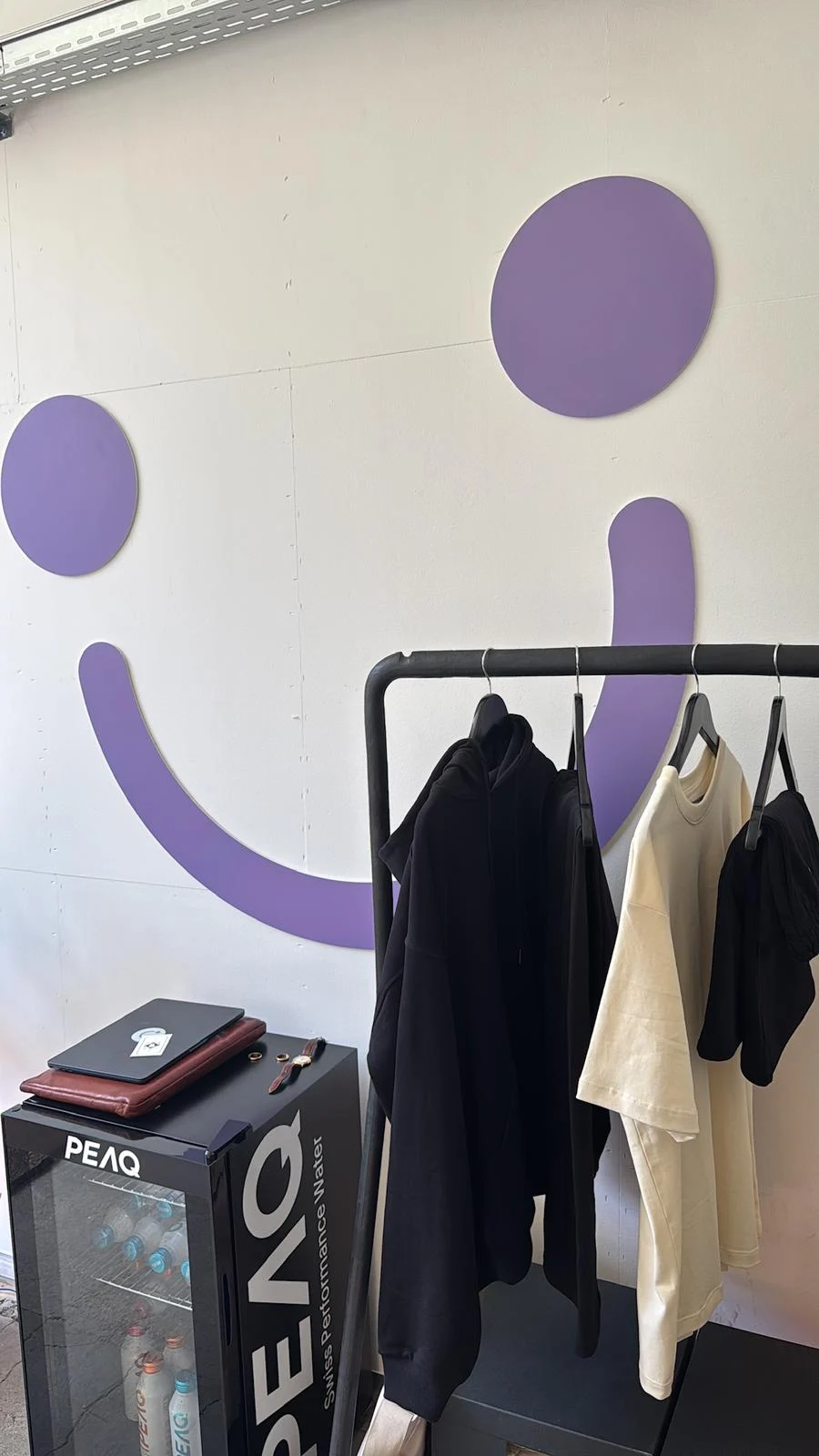 Kleiderstange mit Shirts und Kapuzenpulli im Studio